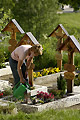 Personne arrosant les fleurs d'une sépulture à Ernen - SUISSE
