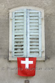 Fenêtre aux volets fermés sur un drapeau suisse - SUISSE