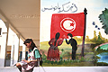 Collgienne tunisienne assise sur le muret de l'cole